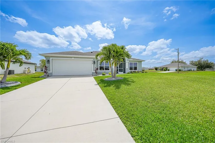 Ranch-style house with driveway, an attached garage, a front lawn, and stucco siding