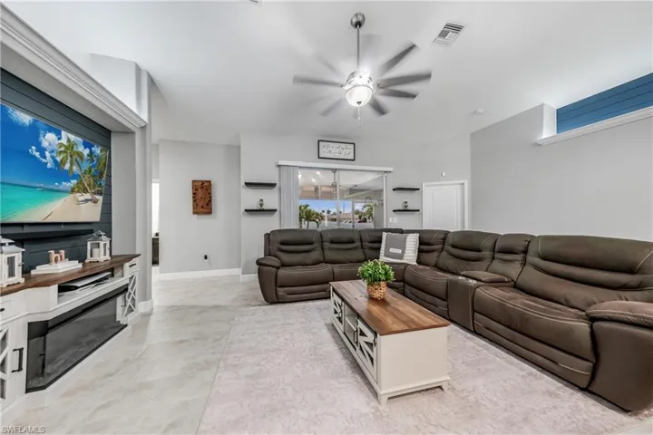 Living area featuring a ceiling fan and baseboards
