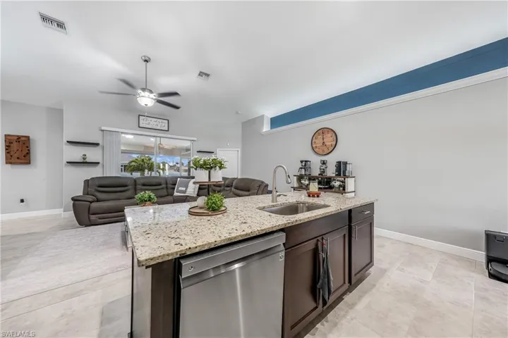 Kitchen with dishwasher, a sink, ceiling fan, and open floor plan