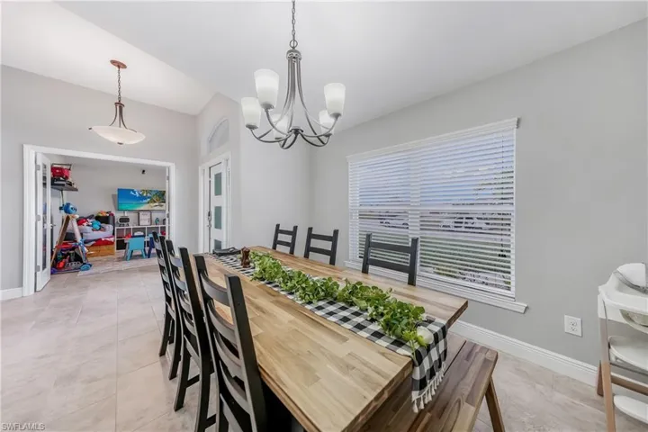 Dining room with a chandelier, baseboards, and light tile patterned floors