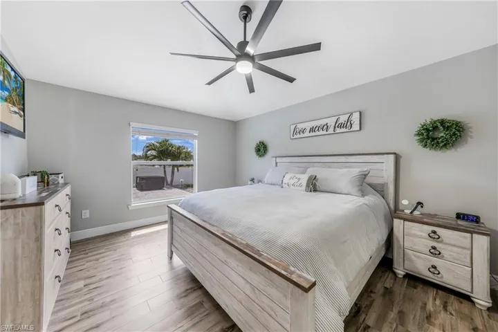 Bedroom featuring wood finished floors, baseboards, and a ceiling fan