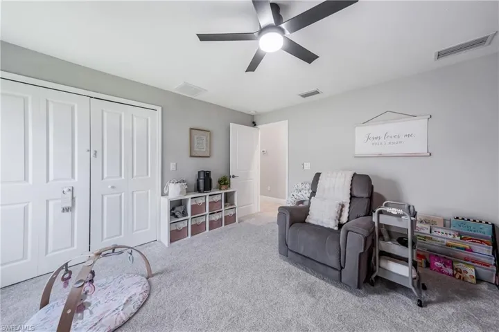 Living area featuring a ceiling fan and carpet flooring