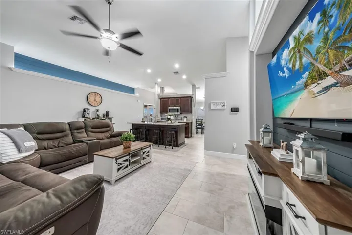 Living area with ceiling fan, recessed lighting, and light tile patterned floors