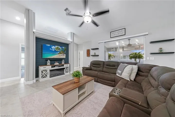 Living room with ceiling fan and light tile patterned floors