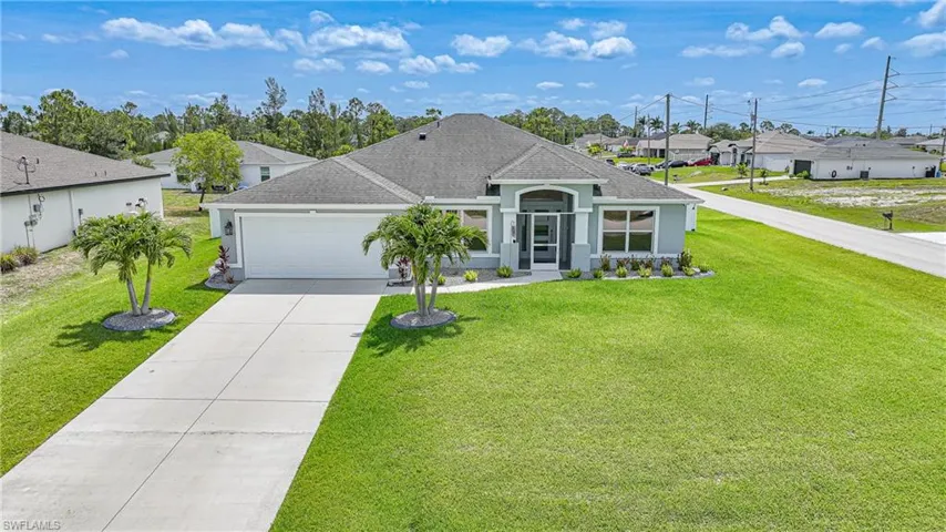 View of front of property featuring a residential view, an attached garage, driveway, and a front lawn