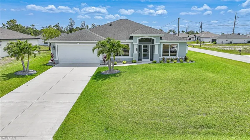 View of front of house featuring driveway, a garage, roof with shingles, and a front lawn