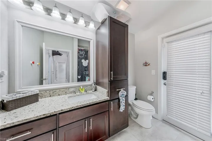 Bathroom with toilet, vanity, and tile patterned floors