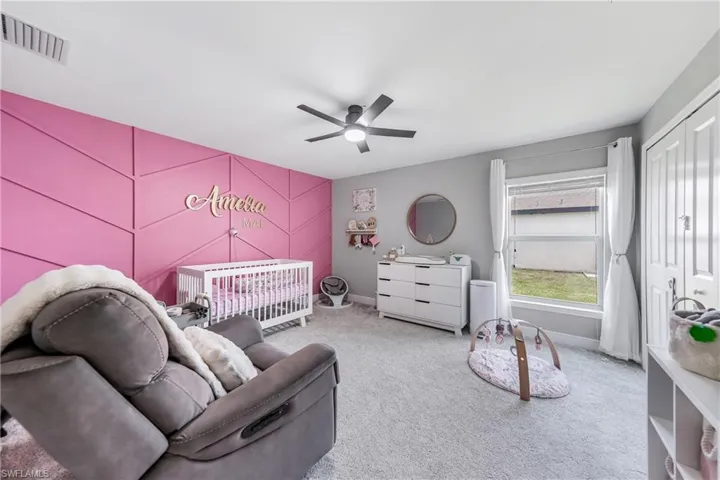 Carpeted bedroom featuring baseboards, multiple windows, a ceiling fan, and a closet