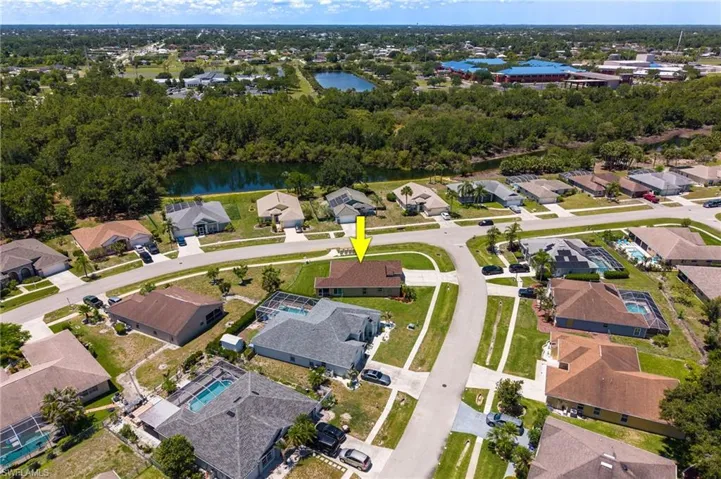 Aerial perspective of a suburban neighborhood featuring a cul-de-sac and residential properties with various roof styles