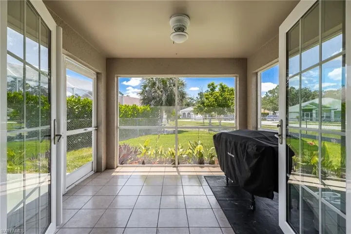 Enclosed patio featuring tiled flooring and a drop ceiling with a central light fixture