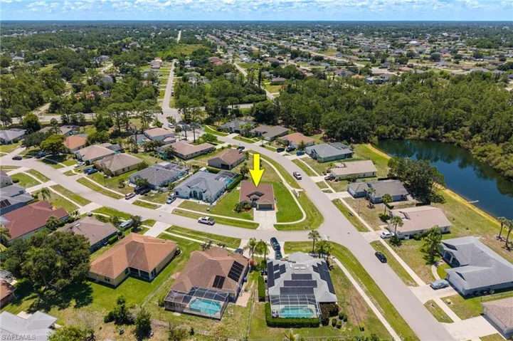 Expansive neighborhood featuring a mix of residential properties with varied rooflines and a prominent water feature
