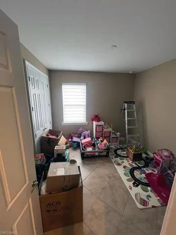 This room features tiled flooring, a window with blinds, and painted walls
