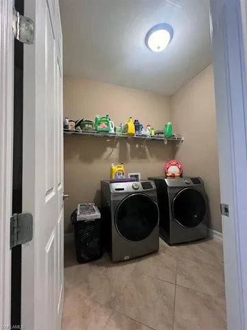 The laundry area features tiled flooring, a mounted shelf, and a ceiling light fixture