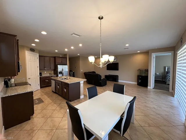 Dining room with a chandelier, recessed lighting, and light tile patterned floors