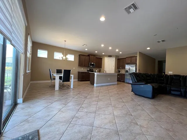 Living area with a chandelier, light tile patterned floors, and recessed lighting