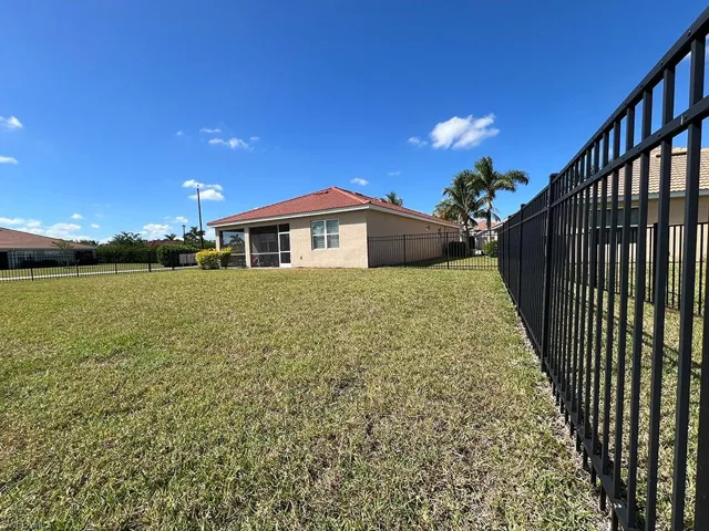 Fenced backyard featuring a sunroom