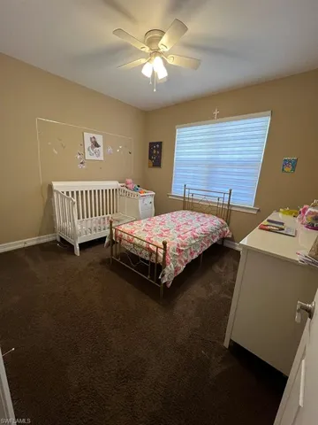 Bedroom featuring dark carpet and ceiling fan