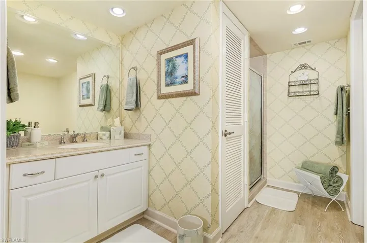 Bathroom featuring vanity, wood-type flooring, and a shower with shower door