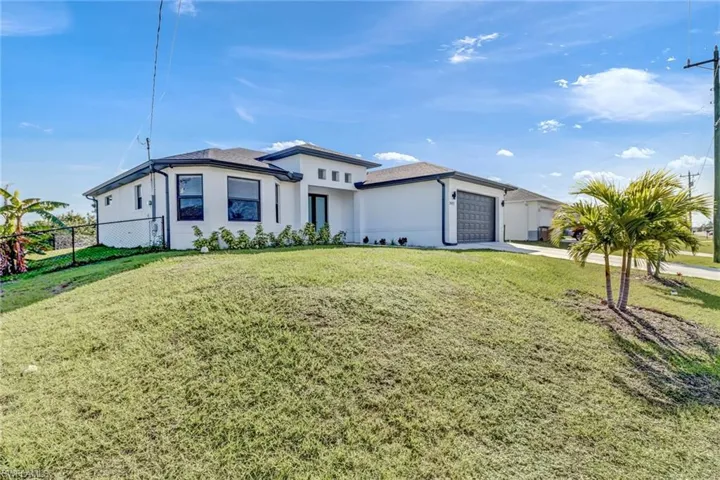 View of front of house featuring a front lawn and a garage