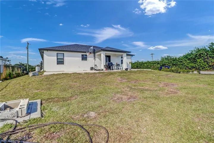 Rear view of house featuring a lawn