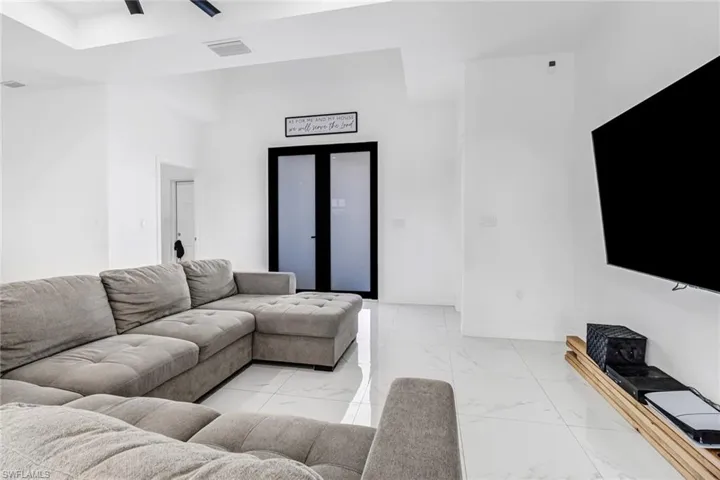 Living room with ceiling fan and light tile patterned floors