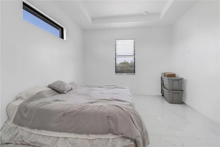 Tiled bedroom with a raised ceiling