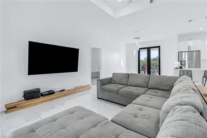 Living room with light tile patterned floors and french doors