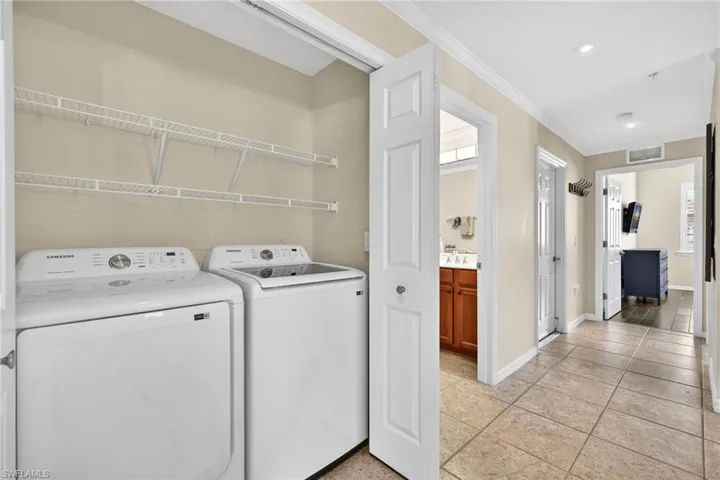 Laundry area featuring crown molding, washer and dryer, and recessed lighting
