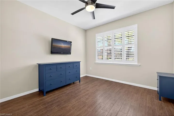 Unfurnished room featuring dark wood finished floors and a ceiling fan