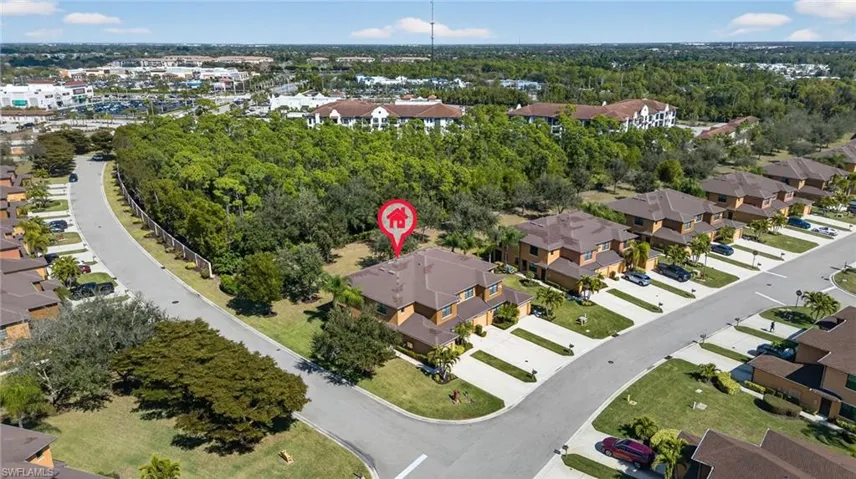 Aerial view of property and surrounding area featuring nearby suburban area