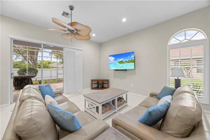 This living area features a ceiling fan, recessed lighting, and tile flooring