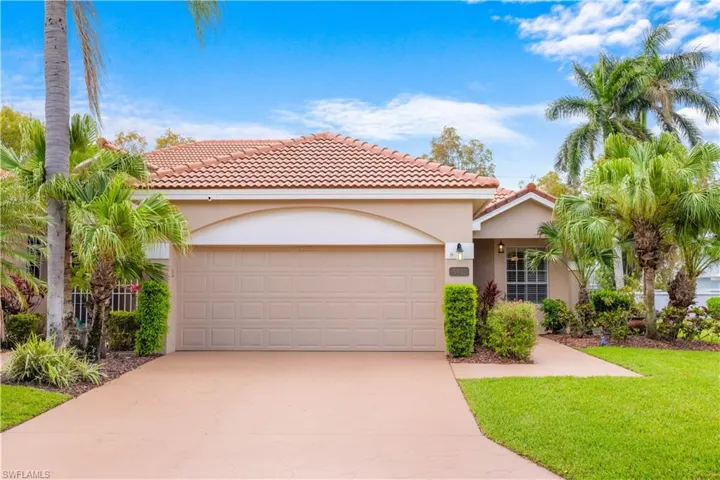 The property features a terracotta tile roof, a two-car garage, and a light-colored stucco exterior