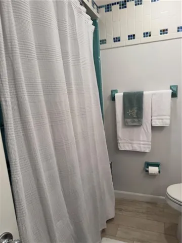 Guest Bathroom featuring light wood-type flooring and curtained shower