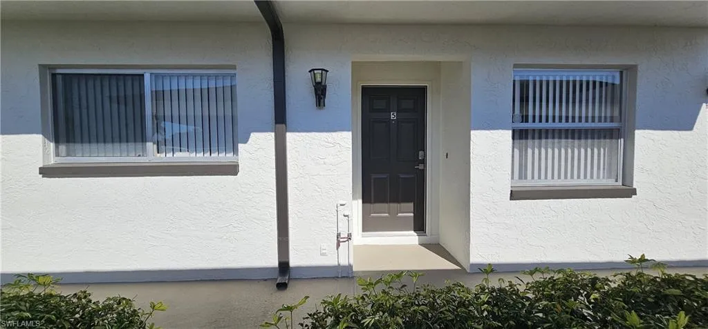 Doorway to property with stucco siding