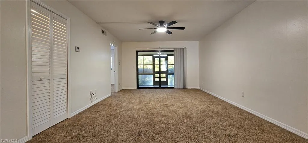 Living room featuring carpet floors and ceiling fan
