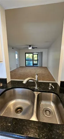 Kitchen view of dark stone counters and carpet