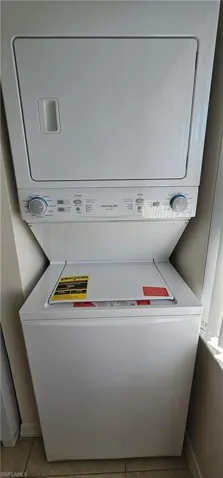 Inside Laundry featuring estacked washer and dryer and light tile patterned flooring