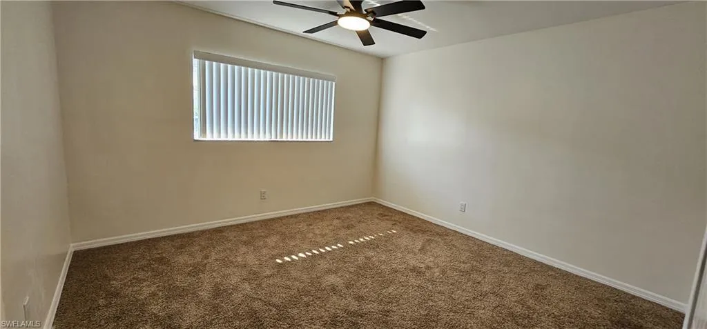 Carpeted Guest room featuring baseboards and a ceiling fan