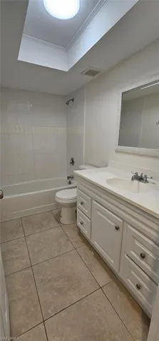 Full Guest bathroom with vanity, shower / bathtub combination, light tile patterned flooring, and ornamental molding