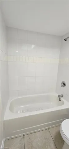 Bathroom with shower / bathtub combination and tile patterned floors