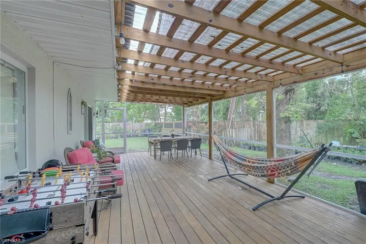 Wooden deck with outdoor dining area and a fenced backyard