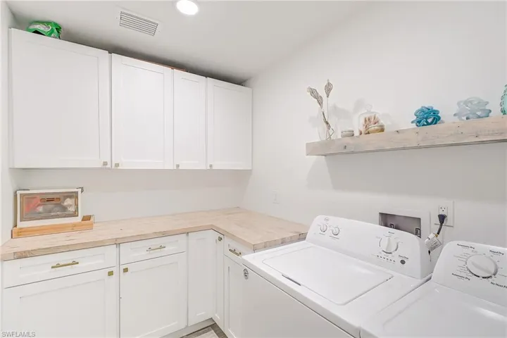 Washroom featuring separate washer and dryer and cabinet space