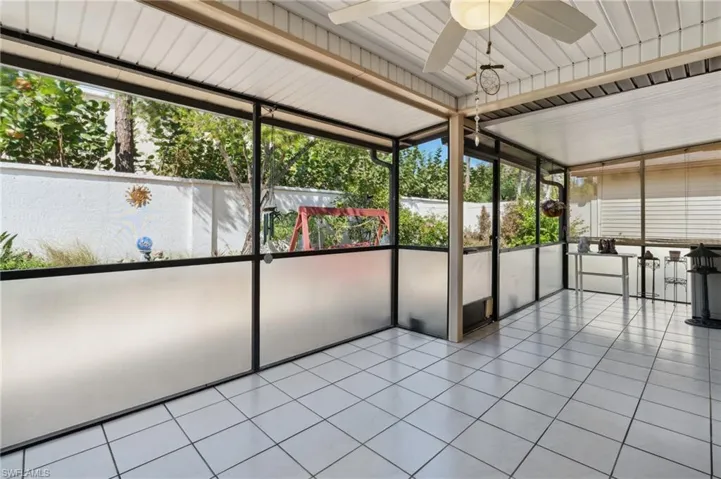 Unfurnished sunroom featuring ceiling fan