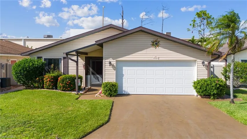 View of front of house featuring a garage and a front yard