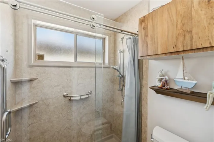 Bathroom with toilet and a shower with shower door