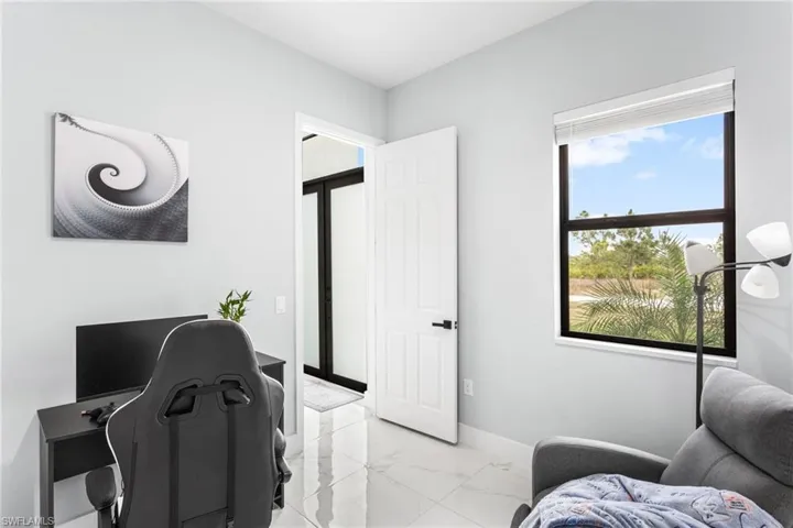 Home office featuring baseboards and light marble finish floors