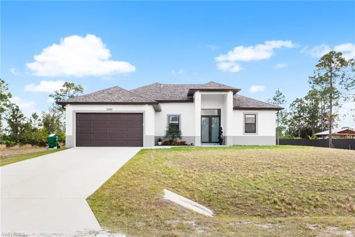 Prairie-style home featuring stucco siding, a garage, and concrete driveway