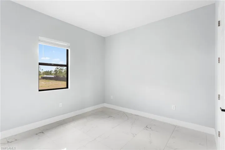 Unfurnished room with baseboards and light marble finish flooring