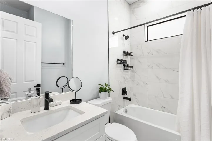 Bathroom with shower / bath combo with shower curtain and vanity