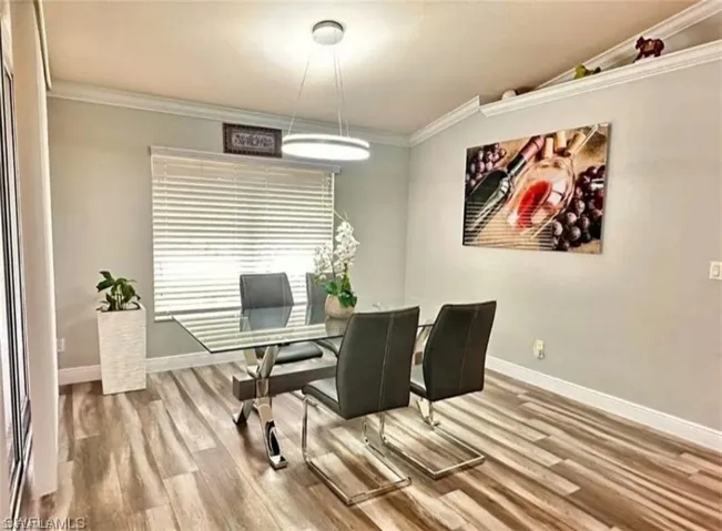 Dining area with ornamental molding and wood finished floors